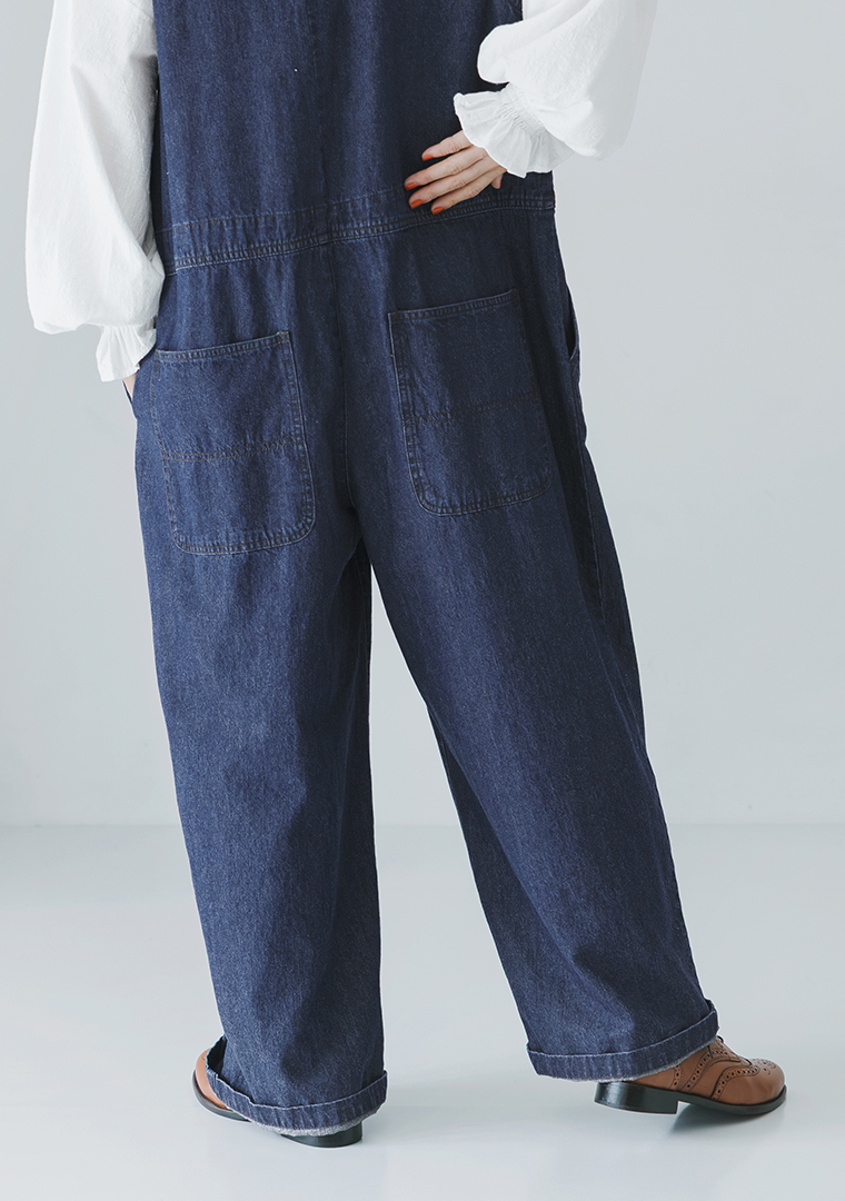 デニムサロペットを着用した女性モデルのバックポケットのアップ