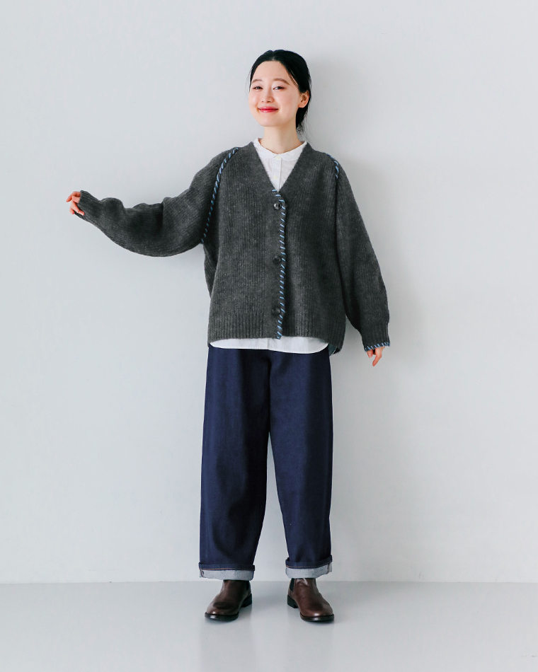 ダークグレーのニットカーディガンに白シャツとデニムを合わせたカジュアルコーディネートの全身写真