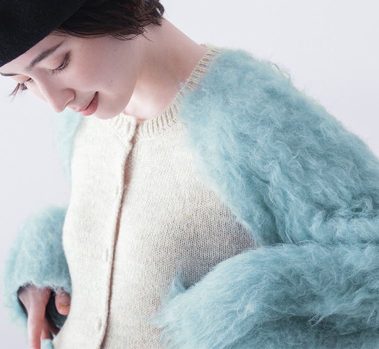 ブルーカーディガンの上半身コーディネート、黒ベレー帽を合わせたスタイル