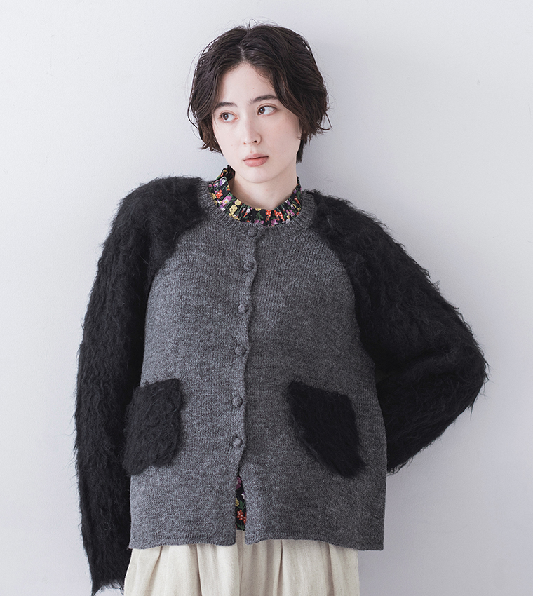 グレーのカーディガンにブラックのファースリーブとポケットを組み合わせた切り替えデザインのディテールカット