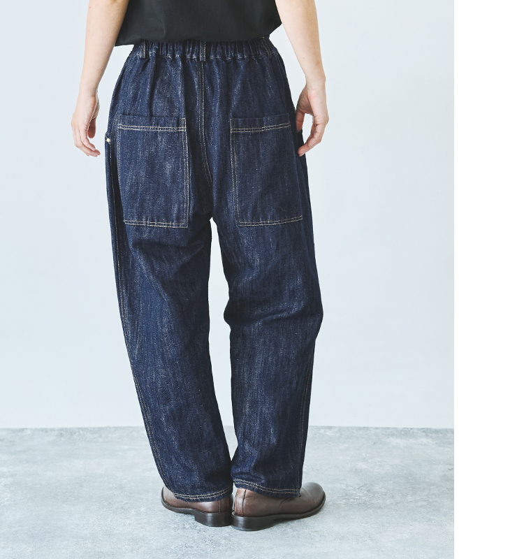 デニムパンツのバックスタイル（ゴムウエスト・大きめポケット付き／黒トップス・ブラウンシューズ着用）