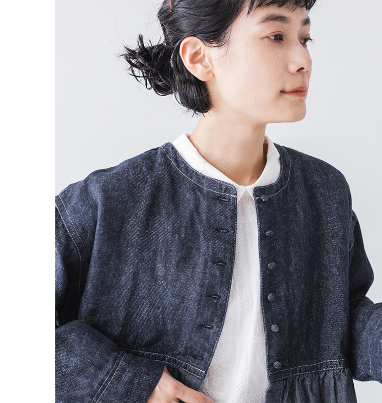 デニムジャケットと白襟ブラウスのレイヤードスタイルの上半身アップ（ショートボブにヘアピンをつけたヘアスタイル）