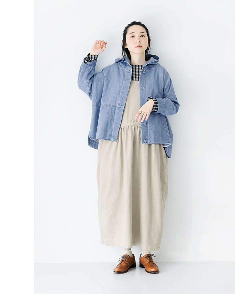 ライトブルーのフード付きデニムジャケットにチェックシャツとベージュのロングワンピースを重ねたカジュアルコーディネート（ブラウンレザーシューズ着用）