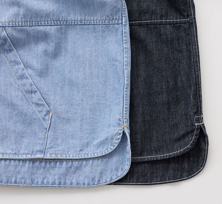 ライトブルーとダークカラーのデニムシャツを重ねて平置きした比較カット（カーブ裾・ステッチ・胸ポケットのディテール）
