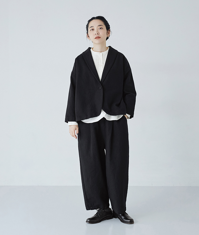 コットンリネンツイル 裾ボタンパンツ ブラックを着用したモデルの全身正面カット