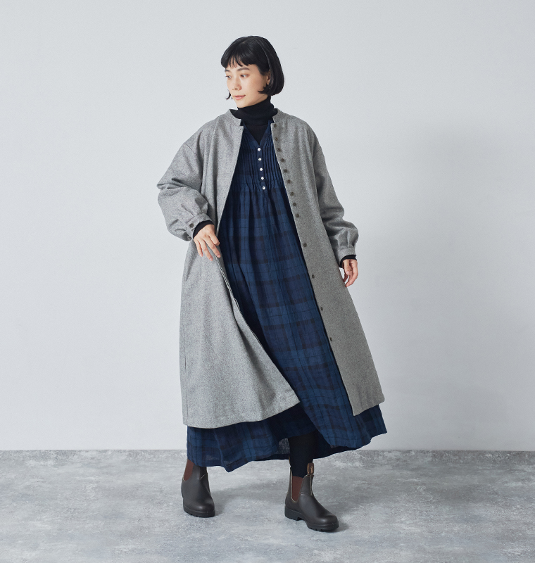 08Mabのウールツイードロングコートを着用した室内コーディネート