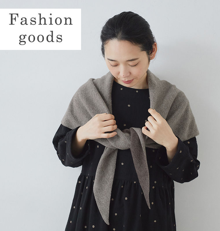 &yarnのウールカシミヤトライアングルストールを肩に掛けて手で押さえた上半身カット