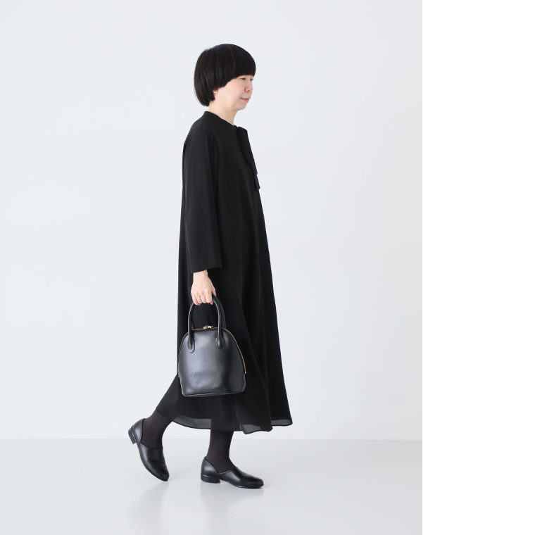 Luuna miu【慶弔両用】大切な日のボウタイAラインワンピースにと黒タイツ、黒のハンドバッグを合わせたコーディネート（歩くポーズ）