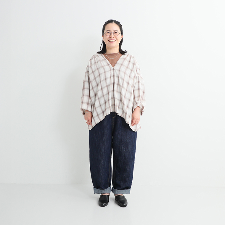  チェック柄のプルオーバーシャツとワイドデニムパンツを合わせたカジュアルコーディネート（黒のスリッポンシューズ）