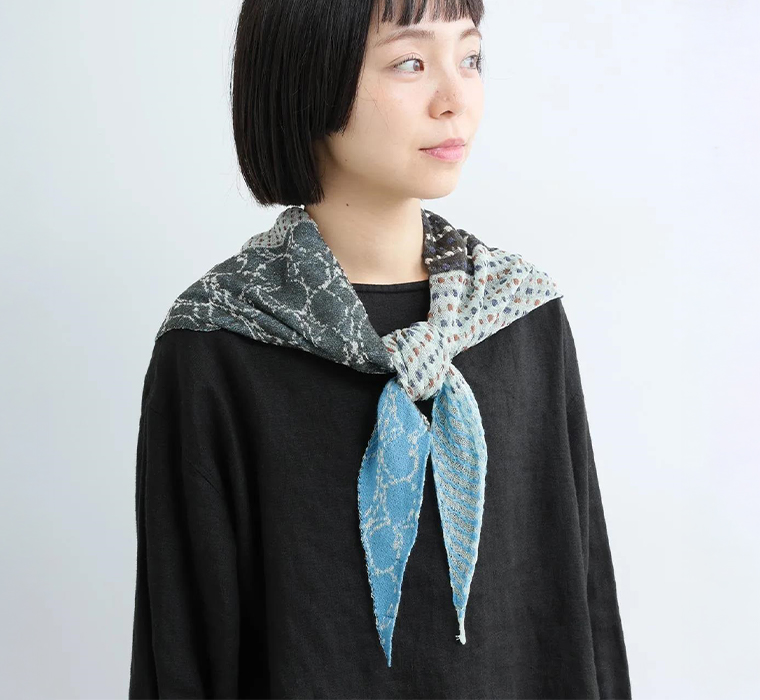 nume コットンドット三角ニットストール(ブルー)を首元に巻いた上半身寄りカット