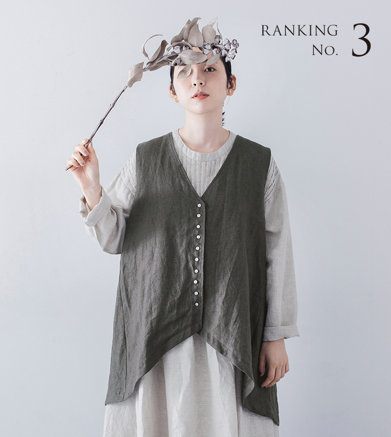 08Mab 9番手リネン 多ボタンベスト 白のロングワンピースとチャコールのベストを合わせたコーディネート（ドライフラワーを頭上に掲げた女性、RANKING No.3の文字入り）