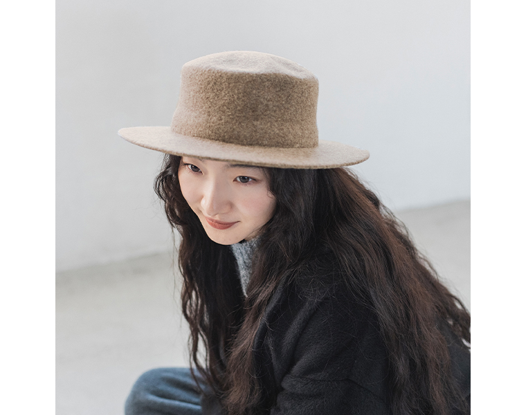 縮絨ウールのカンカン帽をかぶる女性の横向き