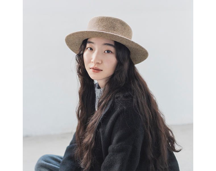 縮絨ウールのカンカン帽をかぶる女性の正面姿