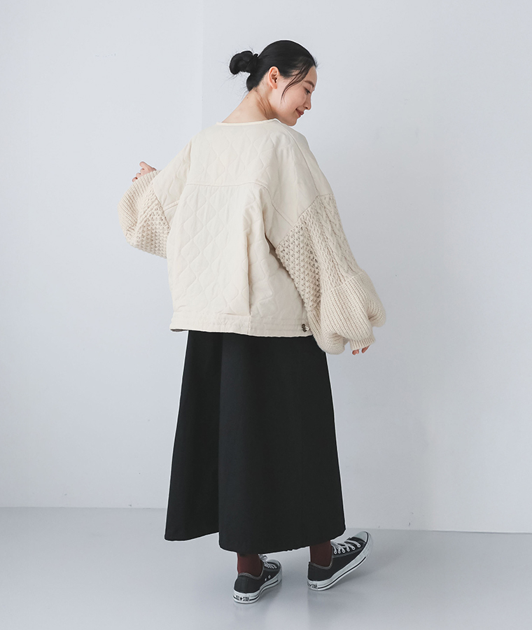 ノーカラークロップドキルティングニットブルゾンを着た女性の後ろ姿シルエット