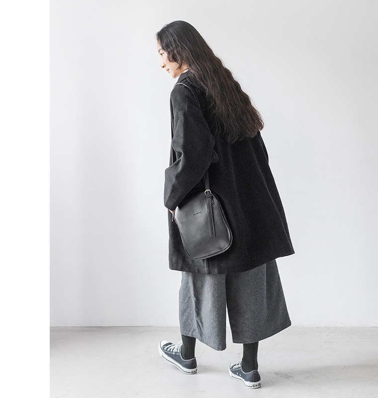 黒のコートとウールミックスガウチョパンツ（ダークグレー）を合わせた女性の後ろ姿