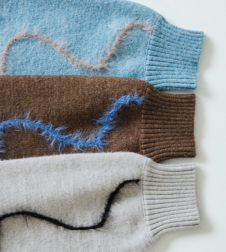 抽象的な黒ラインが入ったグレーニットの素材ディテール（編み目と毛足のあるライン）