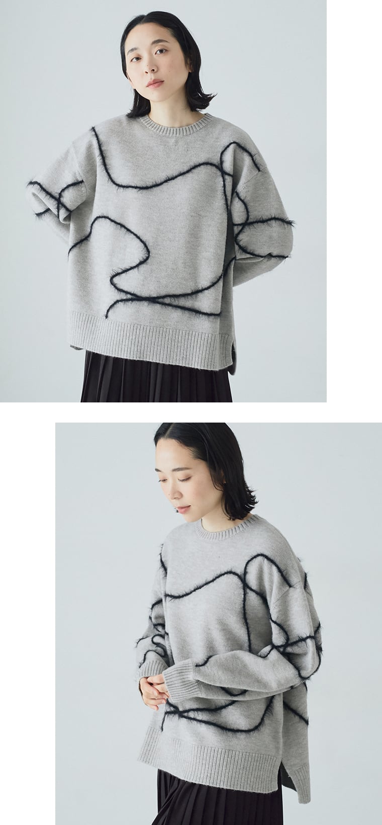 抽象ライン入りグレーニットを黒のプリーツパンツに合わせた正面コーディネート