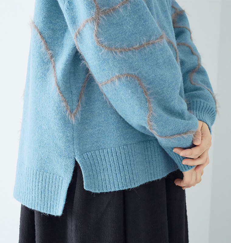 抽象的なブラウンラインが入ったブルーニットの素材ディテール