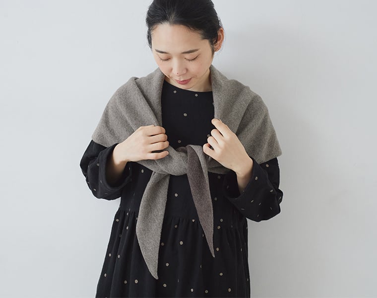 &yarn「ウールカシミヤトライアングルストール」を肩にふんわり巻いた女性のコーディネート