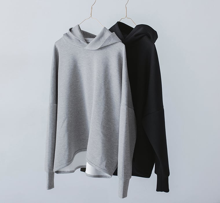 グレーとブラックのパーカーをハンガーに掛けた商品写真