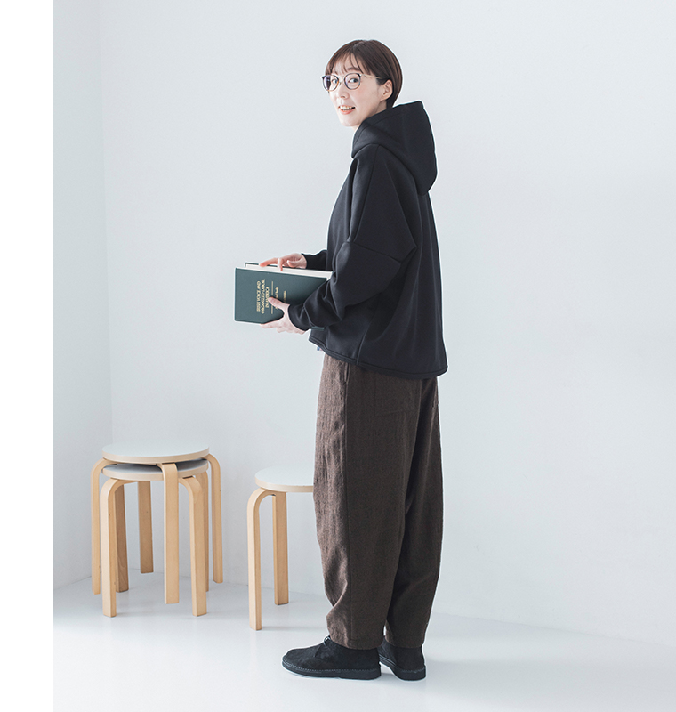 横向きで振り返る姿（黒パーカー・本を手に）