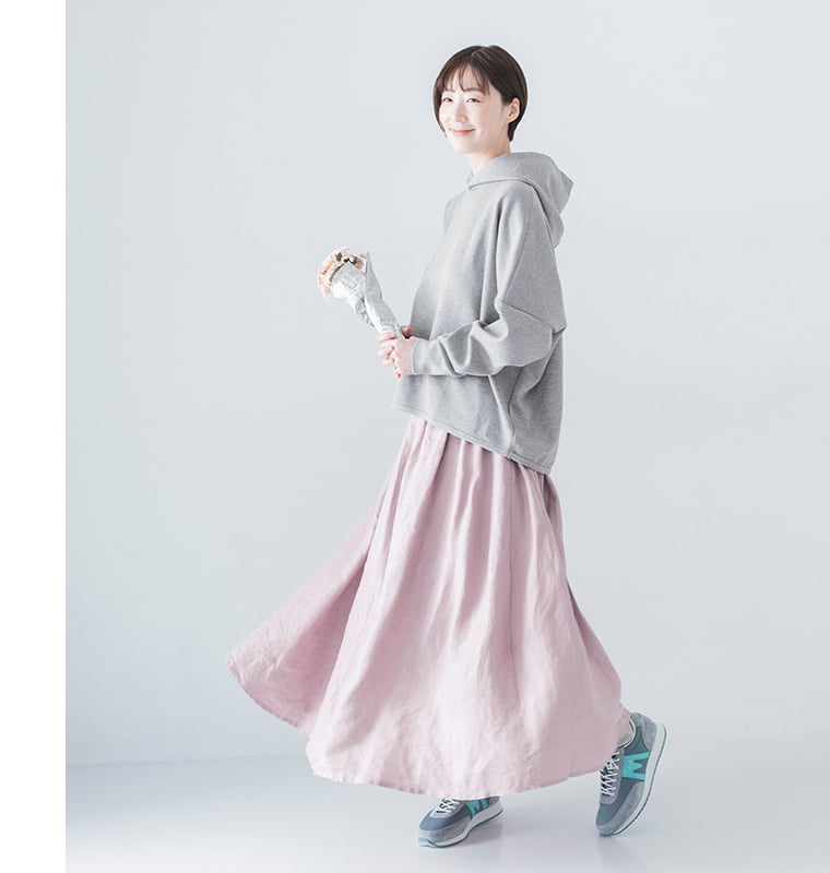グレーパーカーにピンクのロングスカートを合わせたやさしい色合いのコーディネート