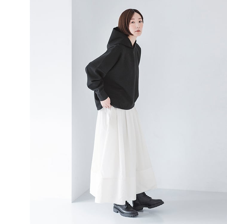 黒のプルオーバーパーカーを白スカートに合わせた大人カジュアルコーデ