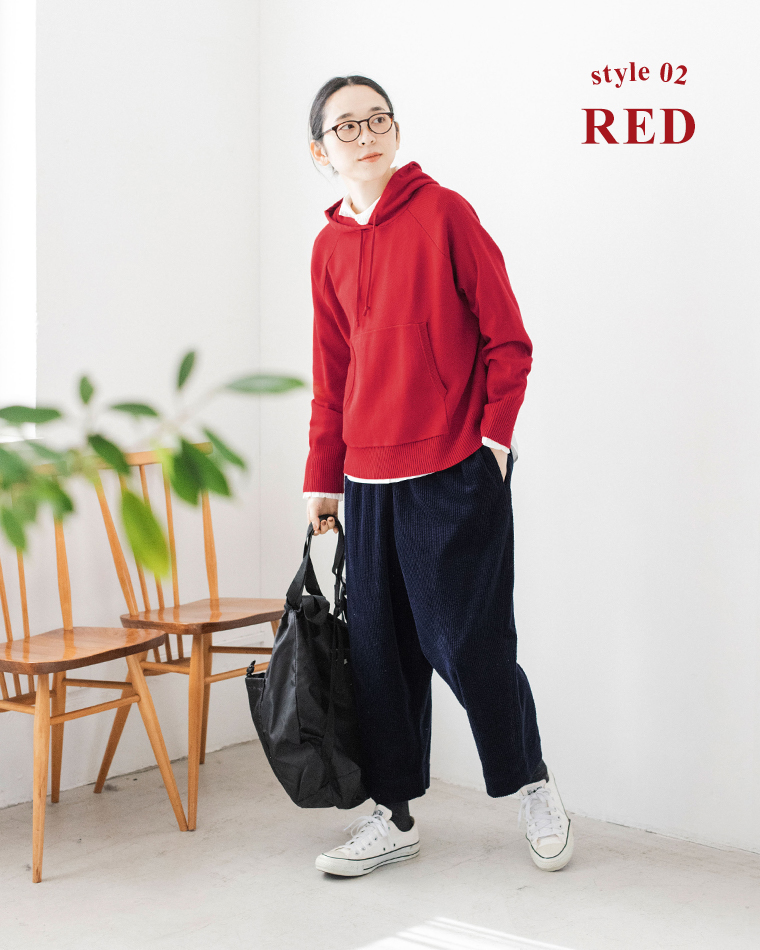 レッドのフーディーとネイビーパンツのカジュアルコーディネート（立ち姿）