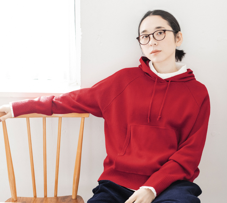 レッドのフーディーとパンツのコーディネート（着席）