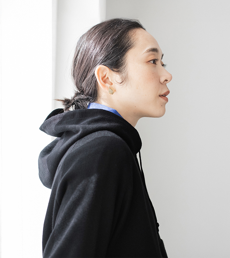 ブラックのフーディーとブルーシャツのレイヤードスタイル（横顔）