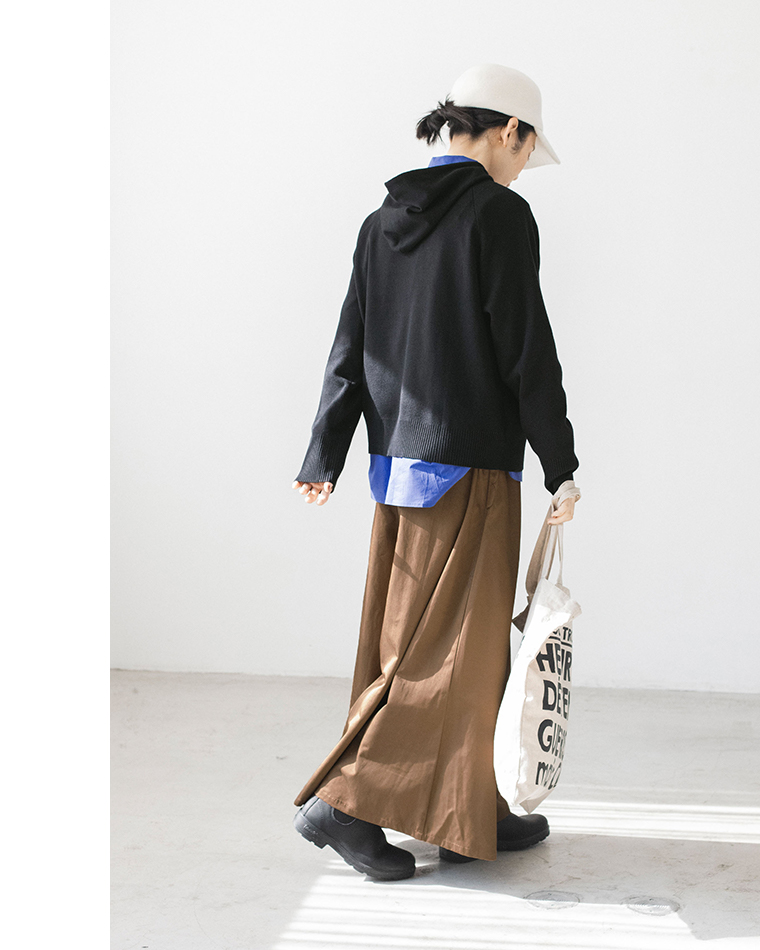 ブラックのフーディーとブラウンスカートのカジュアルコーディネート（歩き姿）