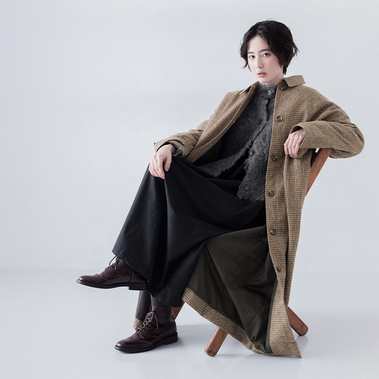 チャコールのシャギーニットカーディガンをコートの中に着用したスタイル