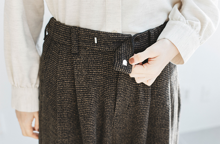 トラッドツイードワイドパンツのウエストディテール／ベルト仕様とタック入りデザインのアップ