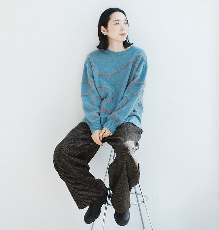 トラッドツイードワイドパンツ〈ブラウン〉着用イメージ／スツールに座ったコーデでワイドシルエットのドレープ感を表現