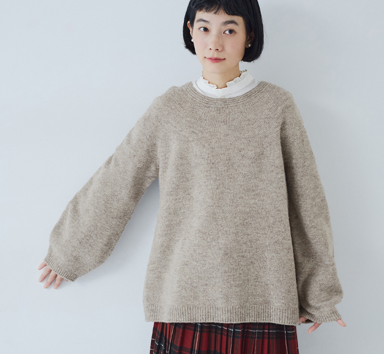 ホールガーメントプルオーバー（ベージュ）にフリルブラウスを重ねた正面アップ