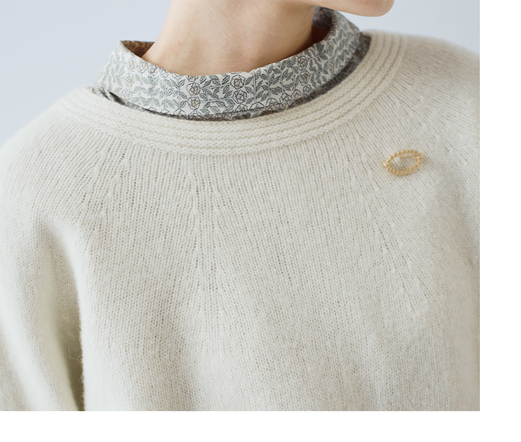 ホールガーメントプルオーバー（オフホワイト）に柄ブラウスを重ねた首元ディテール