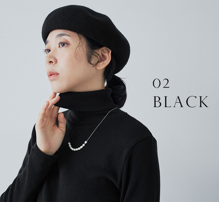 わたしの定番タートルネック（ブラック）を着た女性のバストアップ