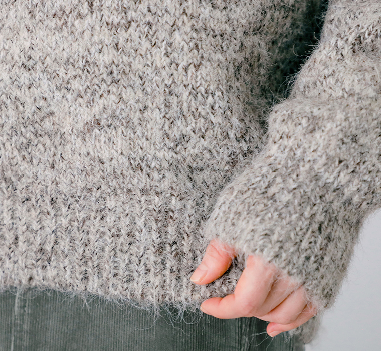 無地ふわふわニットネップBIGプルオーバー（ベージュ系）の裾と袖口の編み地やネップ感がわかる手元のアップ