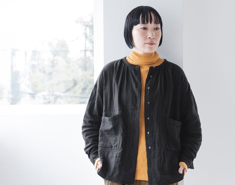 黒のブラウスとマスタードイエローのタートルネックを重ねたコーディネート