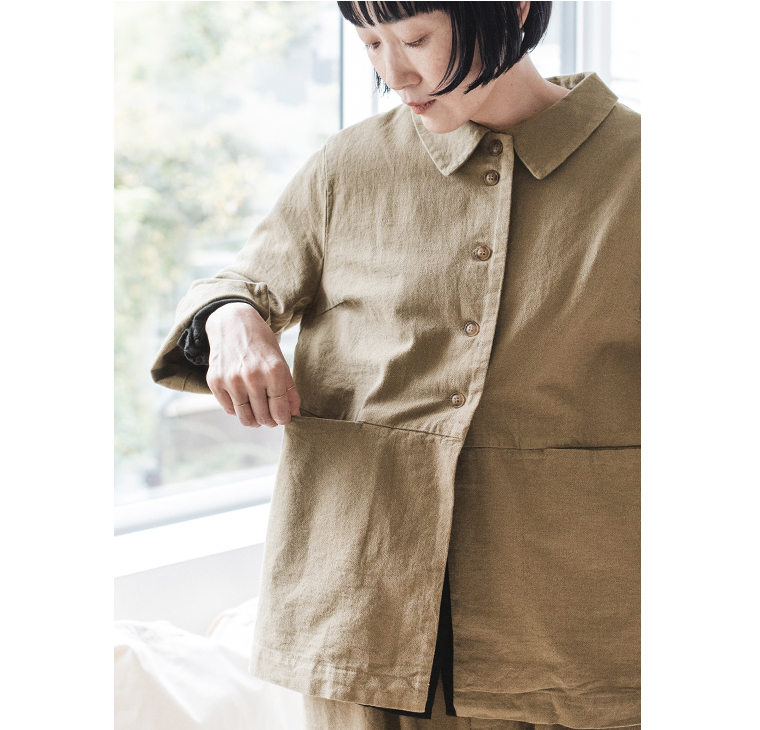 オリーブグリーンのジャケットのフロントポケットを開いたディテールカット