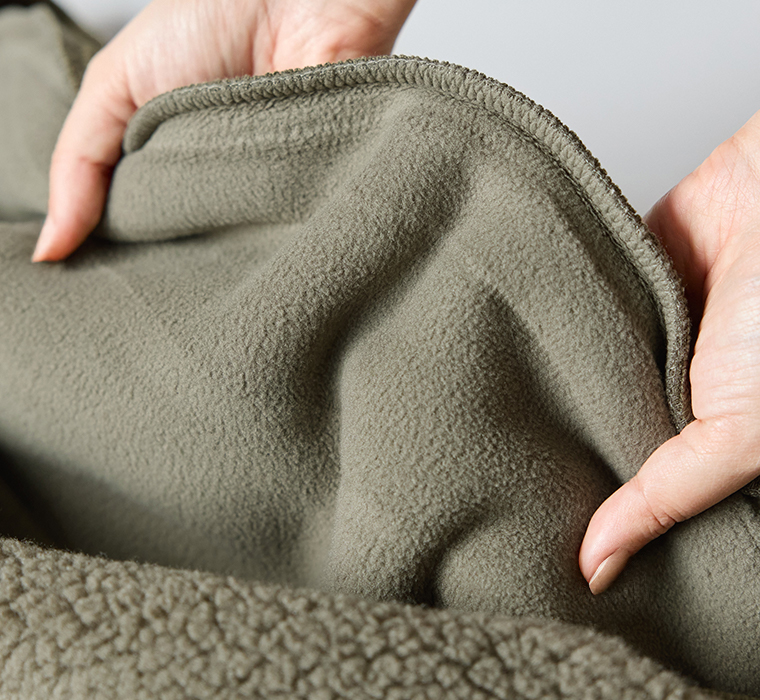  カーキのフリース素材を手で伸ばしたディテールカット