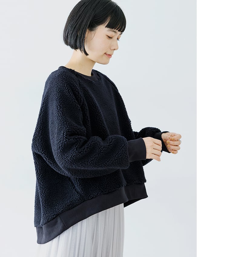 ネイビーのボアプルオーバーの袖を整えるディテールカット