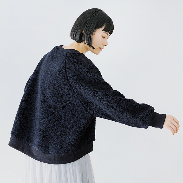 ネイビーのボアプルオーバーを動きのあるポーズで見せたカット