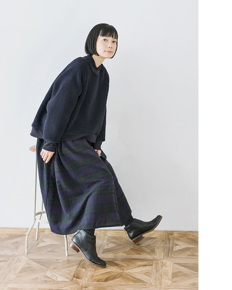 チェック柄ワンピースとネイビーボアプルオーバーの着席コーディネート