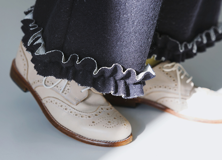 ネイビーのニットパンツに施された裾フリルデザインのクローズアップ