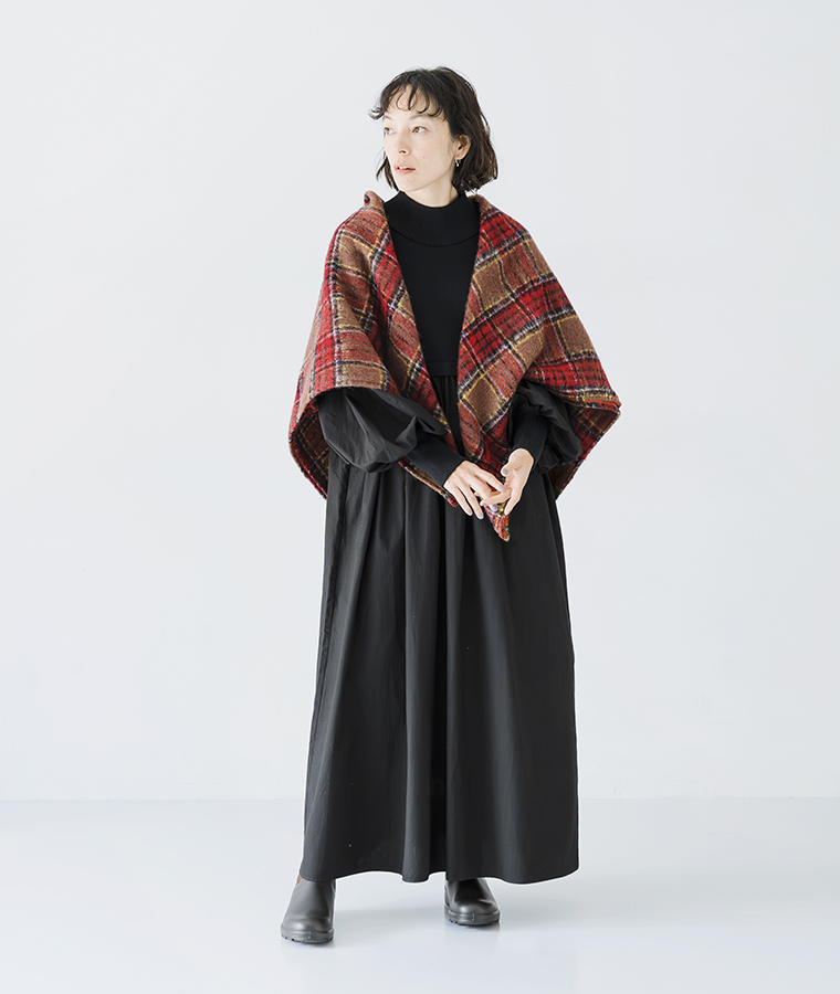 ニット×フハク ハイネックワンピース ブラックを着用しストールを肩に掛けて正面を向いて立つ全身スタイル