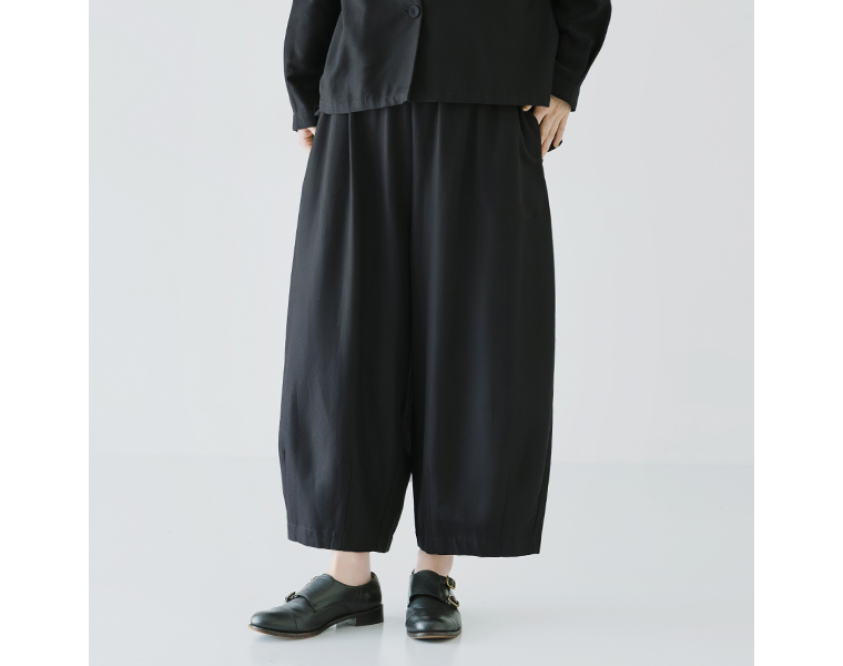 ノーカラージャケットとコクーンパンツを合わせた横向きコーデ。裾のギャザーデザインがアクセント。