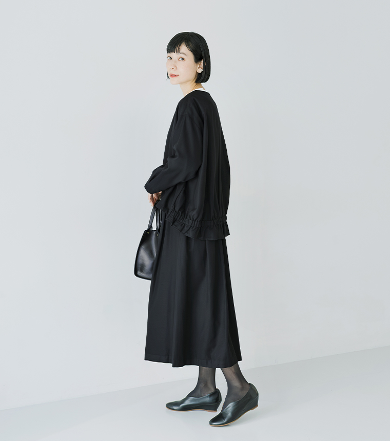 ノーカラージャケットとタックフレアスカートの横向きコーデ。裾ギャザーの後ろ姿がポイント。
