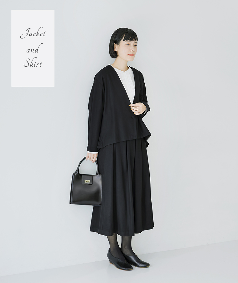 ノーカラージャケットとタックフレアスカートのオケージョンコーデ。白ブラウスで上品にまとめたブラックスタイル。