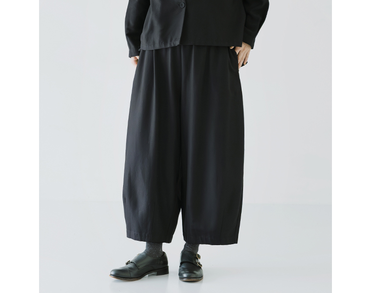 ノーカラージャケットとコクーンパンツを合わせた横向きコーデ。裾のギャザーデザインがアクセント。